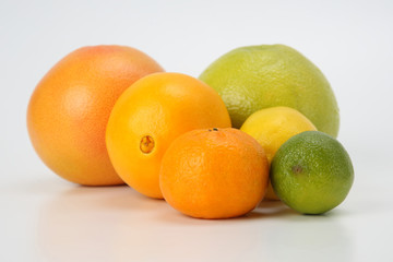 different citrus fruits on white background