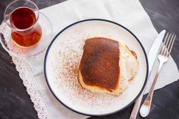 Traditional Turkish dessert Kazandibi with ground cinnamon and turkish tea