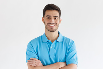 Close up portrait of young smiling handsome guy in blue polo shirt, isolated on gray background