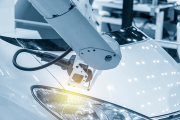 The  CMM laser probe  attach on the robotic arm measuring the car part.Hi technology automotive manufacturing process.