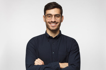 Portrait of young male teacher in deep blue shirt isolated on gray background