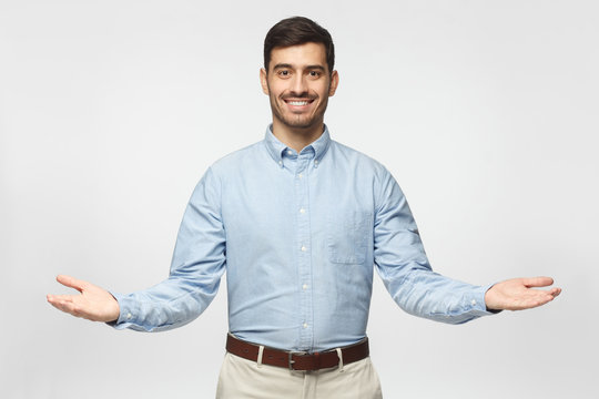 Friendly businessman with welcoming gesture isolated on gray background