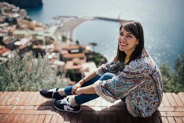 Happy woman traveler smiling at italian coast view.Woman traveling to European south coast.Enoying...