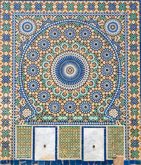 Traditional ornamental drinking fountain in medina in Meknes, Morocco. Decorated fountain with...