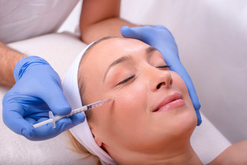 Beautiful young woman during skin treatment with hyaluronic acid