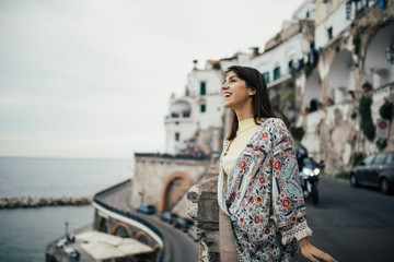 Italian young woman enjoying beautiful sunset in Amalfi on Amalfi coast in southern Italy.Italian experience, day trip to seaside, visiting romantic coastal towns.Vacation destination