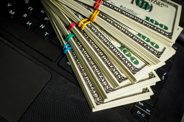 Many packs of dollars on a laptop keyboard