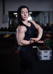 fitness girl resting and showing off her muscles in the gym.