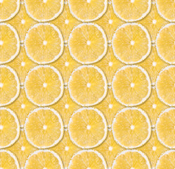 Background of fresh yellow lemon slices. Seamless pattern. Close up. Studio photography.