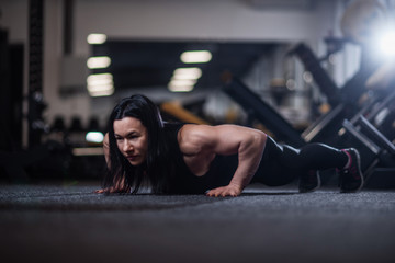 Fototapeta na wymiar athletic woman doing push-ups in the gym. Woman doing yoga