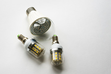 Three led energy saving lamps on white background. Copy space.