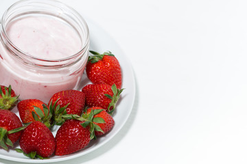 strawberry yogurt in glass jar and fresh berries on white background, top view