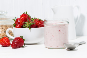 strawberry yogurt, granola and fresh berries on white background