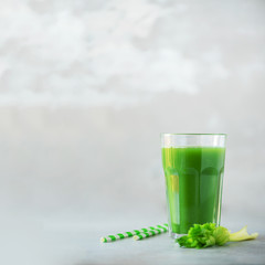 Glass of green celery smoothie on grey concrete background. Banner with copy space. Square crop. Vegan, alkaline healthy diet concept