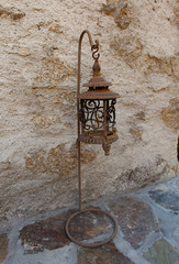 una vecchia lampada arrugginita col suo piedistallo - 242005895