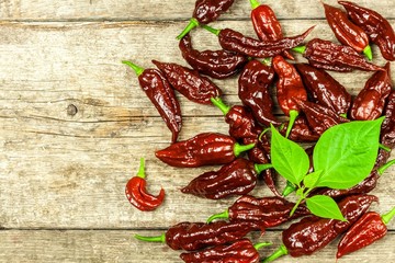 Chili pepper on wooden background.Extra hot chili pepper Naga Bhut Jolokia Chocolate.Raw food. Sale Chili.
