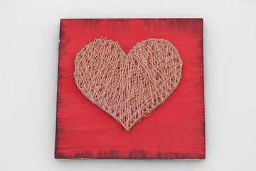 panels of thread and nails, heart on a red background. string art. gift or decoration for February 14 and March 8. with love