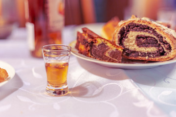 Vodka in a glass and cake on the table
