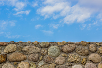 stone wall material texture board with empty blue sky background wallpaper patter for copy space for your text