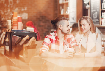 Young happy couple on date in cafe, drinking coffee, smiling. Concept of love, lovers