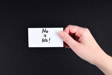 No is no text on a card in woman hand  on a black background.