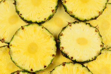 Pineapple juicy yellow slices background. Top view.