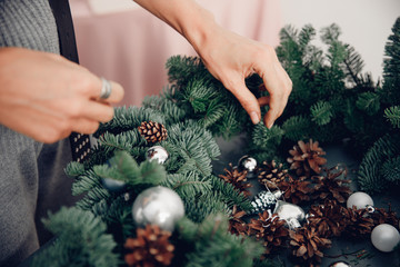 Woman decorating coniferous wreat Christmas tree workshop DIY