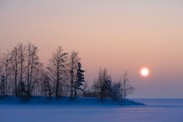 Sunshine over frozen lake on a cold winter day.