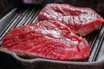 portion of fresh boneless raw beef steak meat in hot pan, close up