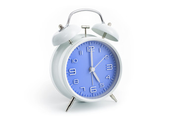 Twin bells analogue alarm clock with blue clock face shows five hours, 5 AM PM; concept on white...