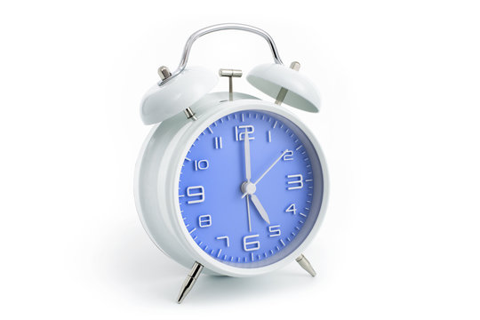 Twin bells analogue alarm clock with blue clock face shows five hours, 5 AM PM; concept on white background
