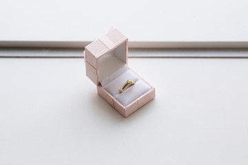 Gold ring with a precious stone in a pink jewelry box