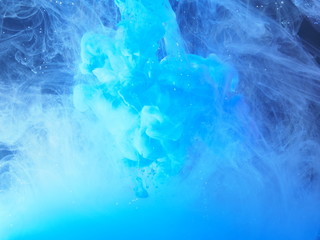 Blue paint is mixed with water. The dissolution of ink in water.