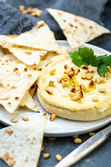 Traditional hummus with pine nuts and pita bread.