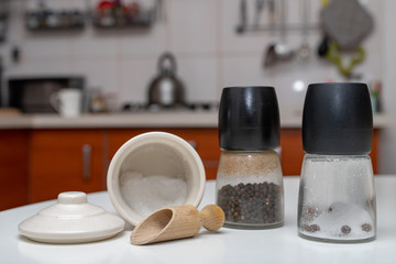 Spices in containers on the kitchen table. Equipment in the home kitchen.