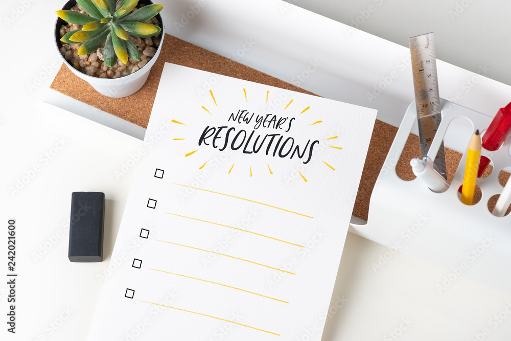 Poster top view new year's resolutions checklist on white paper note on modern office stationery on white t