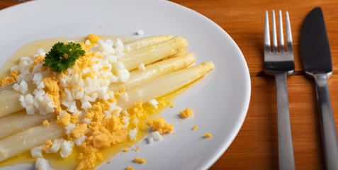 cooked white asparagus with butter and boiled eggs