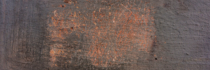 wall covered with old crumbling cement plaster with traces of paint.