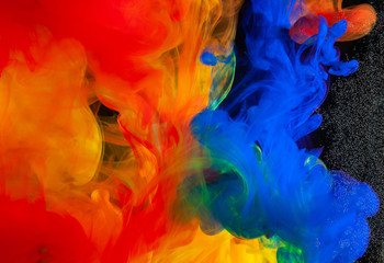 Spill and mix paint in water on a black background