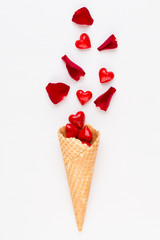Creative composition for Valentines day with waffle cone, mixed hearts on white background top view. Fashion flat lay.