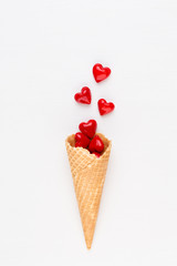 Creative composition for Valentines day with waffle cone, mixed hearts on white background top view. Fashion flat lay.