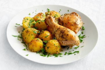potatoes and chicken tight and leg roasted with herbs decorated with parsley