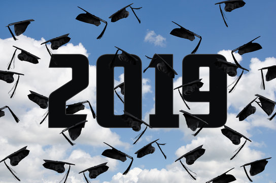 black graduation caps in summer sky with white clouds with year 2019 text