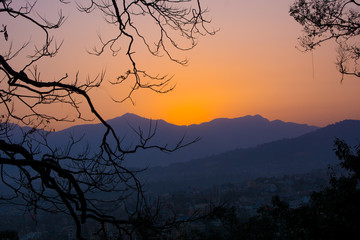 View of a sunset enclosed in a frame of trees to mean a concept of tourism