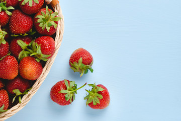 Food concept with sweet delicious strawberries on blue background, healthy organic food image, minimalistic fruit concept. top view.