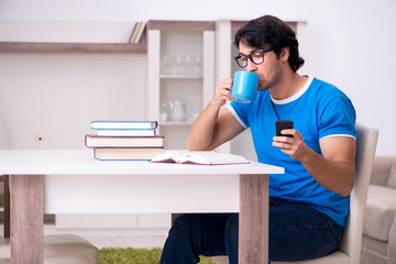 Young handsome student studying at home 