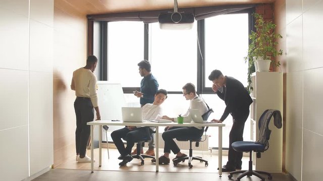 Business team of diverse multicultural people making contracts in an open space office interior with a panoramic window