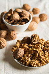 Peeled walnuts and shells on a light background