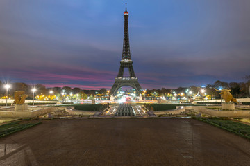 Very early morning sunrise on the Eiffel tower not lit at all, view from the Trocadero fountain water in Paris, one of the most visited building by the tourists