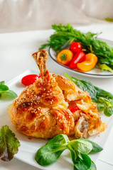 Chicken legs in dough with vegetables and lettuce.